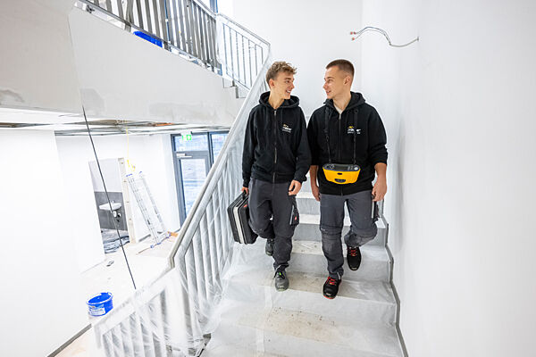 Zwei Auszubildende im Gespräch auf einer Treppe